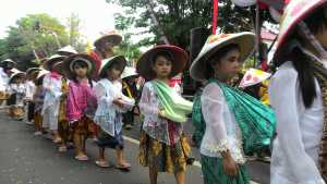 Siswa TK mengenakan pakaian petani saat mengikuti karnaval.