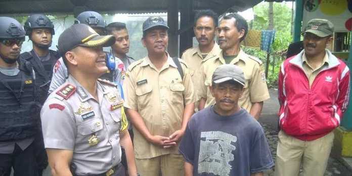 Kapolres Malang, Yudho Nugroho, saat berbincang dengan juru kunci makam mbah Setyo Setuhu.