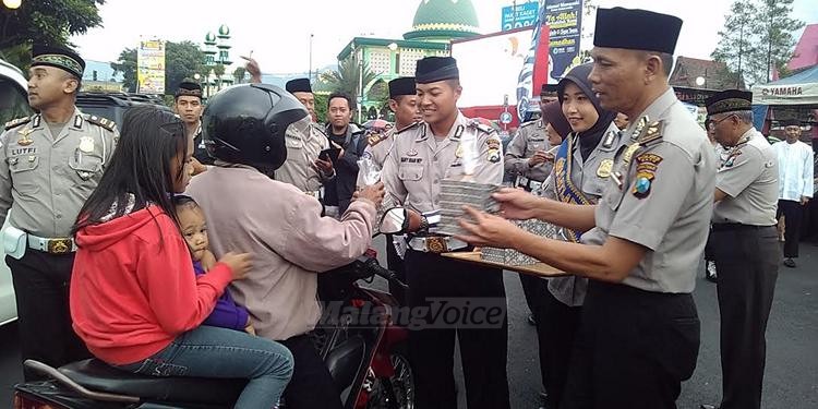 Anggota Polres Batu membagikan takjil kepada pengendara jalan raya di Alun-alun Batu (fathul)