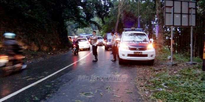 Petugas saat mengatur lalu lintas di sepanjang jalur payung, Songgoriti, Kota Batu.