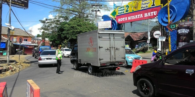 Petugas kepolisian saat mengurai kepadatan arus lalu lintas di Jalan Dewi Sartika.(Miski)