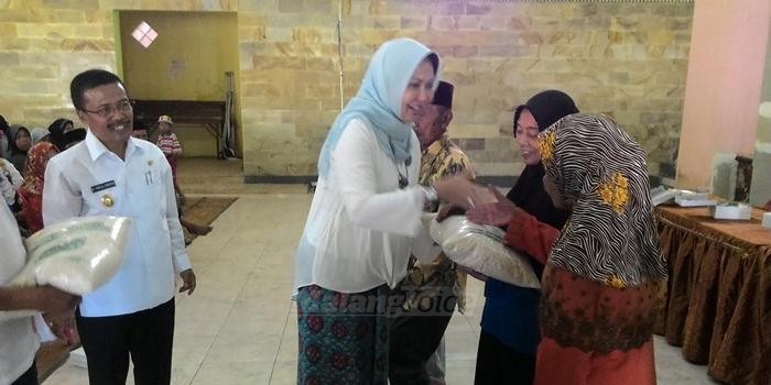 Ketua PKK Dewanti Rumpoko bersama Wakil Wali Kota Batu, Punjul Santoso saat menyerahkan bantuan beras ke warga.(Miski)