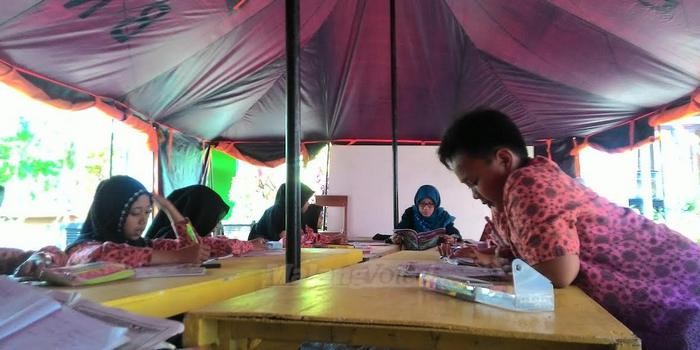 Siswa-siswi kelas V MI Darul Hikam, Desa Torongrejo, Kota Batu saat mengikuti proses belajar mengajar di kelas darurat, setelah ruang kelas rusak diterjang puting beliung, Jumat (28/10).(Miski)