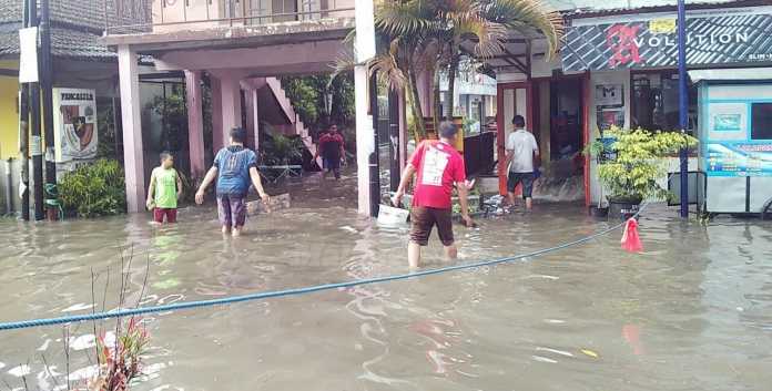 Warga mencoba membersihkan sisa banjir di Jalan Galunggung - Bendungan Sutami Kota Malang. (Muhammad Choirul)