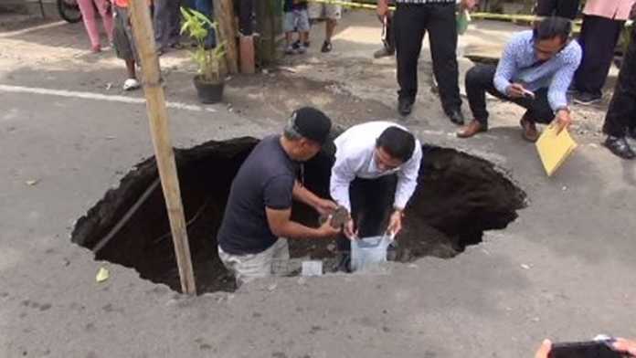 Petugas Unit IV Tindak Pidana Korupsi mengecek lubang di Jalan Terusan Bondowoso.