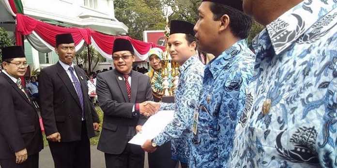 Wakil Wali Kota Malang, Sutiaji, menyerahkan penghargaan kepada kecamatan pemenang Lomba Pengarsipan, usai upacara. (Muhammad Choirul)