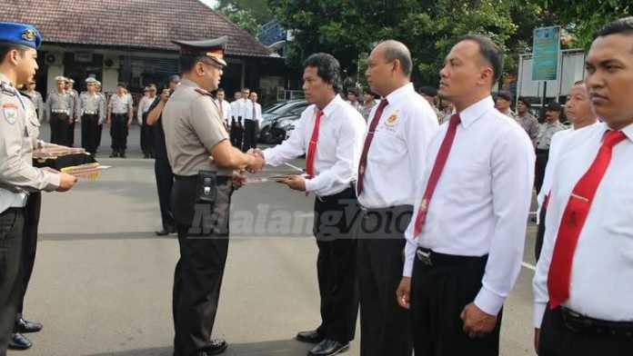 Kapolres Malang Kota AKBP Decky Hendarsono, memberikan penghargaan pada anggota berprestasi. (deny)