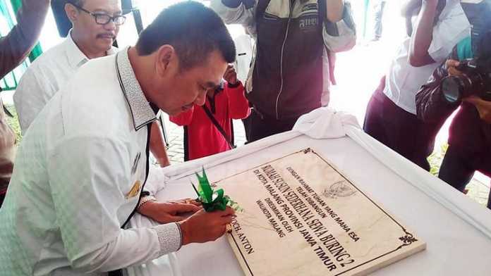 Wali Kota Malang, HM Anton, menandatangani prasasti peresmian Rusunawa Buring 2. (Muhammad Choirul)