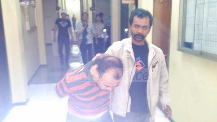 Yamin Dopu saat dijemput polisi di kantornya, Kamis (22/12) kemarin.