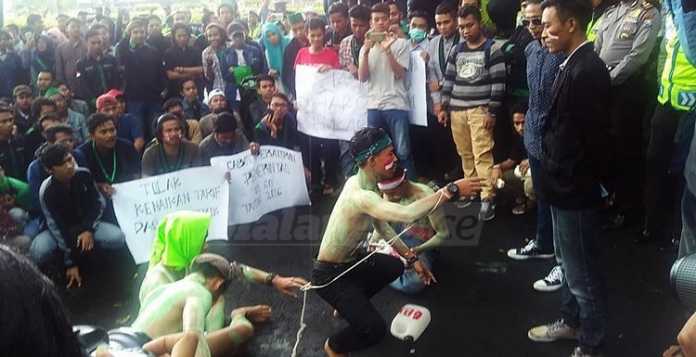 Sejumlah demonstran melaksanakan aksi treatrikal di depan Gedung DPRD Kota Malang. (Muhammad Choirul)