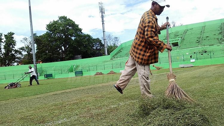 Petugas kebersihan membersihkan rumput potongan rumput di Stadion Gajayana. (Muhammad Choirul)