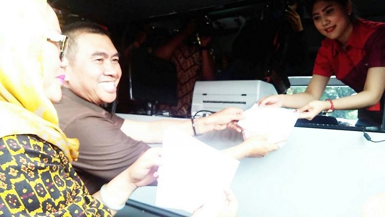 Wali Kota Malang, HM Anton, didampingi istri, Hj Dewi Farida Suryani, membayar pajak lewat mobil layanan pajak. (Muhammad Choirul)