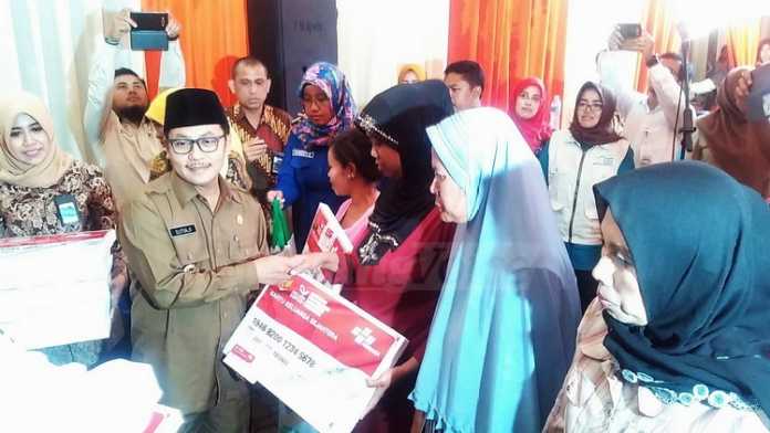 Wakil Wali Kota Malang, Sutiaji, menyerahkan bantuan non-tunai kepada penerima Program Keluarga Harapan. (Muhammad Choirul)
