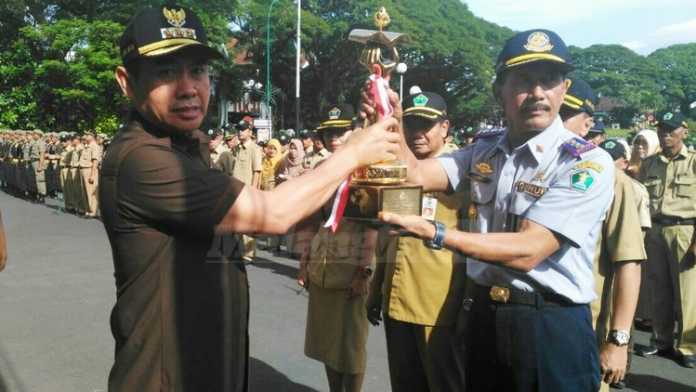 Kepala Dinas Perhubungan Kota Malang, Kusnadi, menyerahkan piala Wahana Tata Nugraha (WTN) kepada Wali Kota, HM Anton. (Muhammad Choirul)
