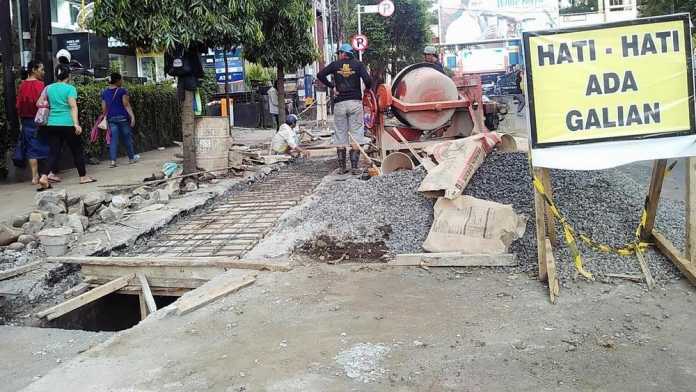 Para pekerja menggarap perbaikan drainase di Jalan Merdeka. (Muhammad Choirul)