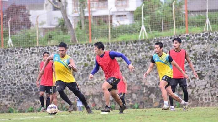 Pemain muda Arema FC, Bagas Adi berduel dengan Beny Wahyudi. (deny)