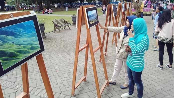 Pengunjung menikmati pameran foto karya Himpunan Mahasiswa Jurnalistik Fotografi (HMJF) Universitas Kanjuruhan Malang. (Muhammad Choirul)