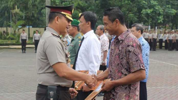 Kapolres Malang, AKBP Yade Setiawan Ujung, saat menyerahkan penghargaan ke sekolah, anggota dan masyarakat.(ist)