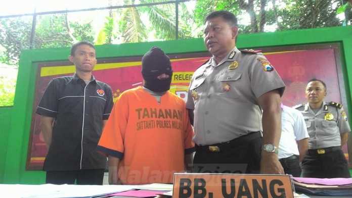 Kepala Desa Tegalgondo, Kecamatan Karangploso, Usman Junaidi, saat rilis kasus di Polres Malang.(Miski)