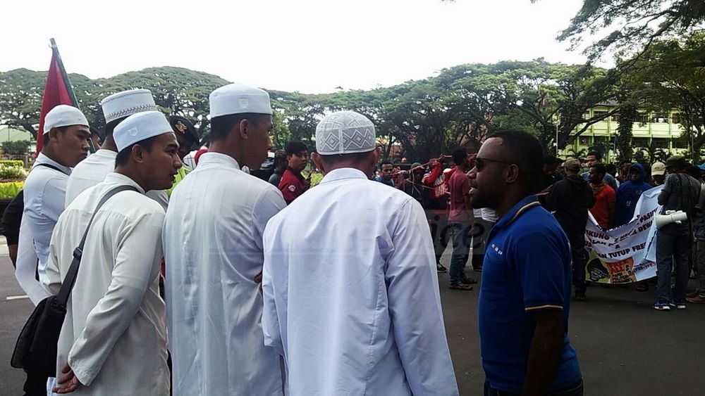 Lima santri Kota Malang bersiaga di hadapan puluhan Aliansi Mahasiswa Papua (AMP) yang berunjuk rasa di Bundaran Tugu. (Muhammad Choirul)