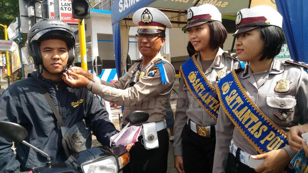 Polisi memberikan helm gratis (Anja)