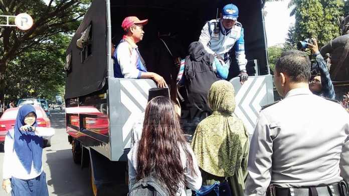 Penumpang terlantar diangkut kendaraan milik Polres Malang Kota. (Muhammad Choirul)