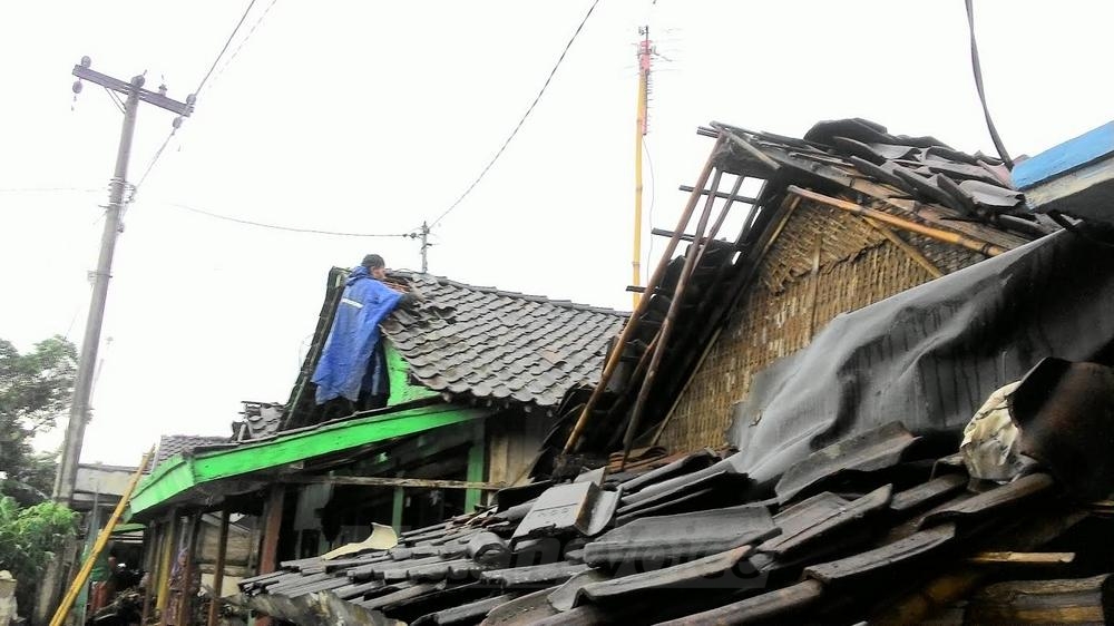 Salah satu warga di Desa Wonorejo mulai memperbaiki bagian atapnya yang rusak pasca diterjang puting beliung.(miski)