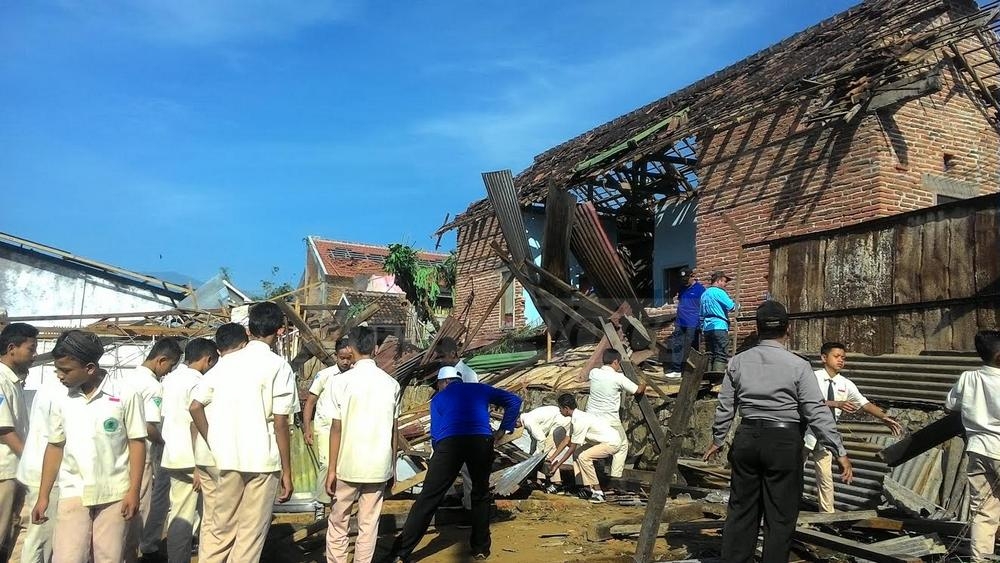 Siswa SMP Islam Fatahillah saat membantu membersihkan material bencana pasca Desa Langlang diterjang puting beliung.(miski)
