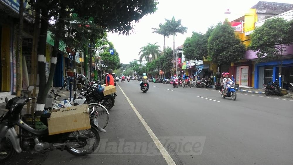Juru Parkir saat berjaga di lahan parkir sepanjang Jalan Achmad Yani, Kepanjen, Kabupaten Malang.(Miski)