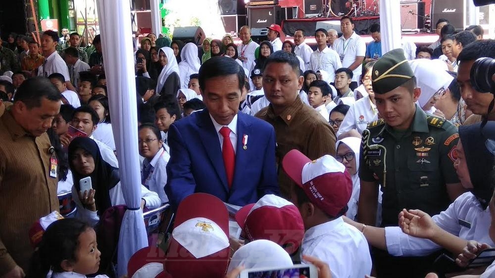 Jokowi memberikan KIP pada siswa. (deny)