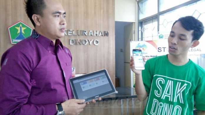 Lurah Dinoyo, Arif Tri Sastyawan, menunjukkan cara kerja aplikasi Sakdino. (Muhammad Choirul)