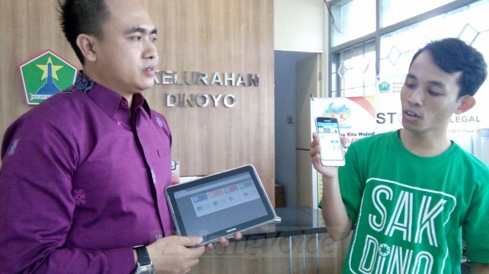 Lurah Dinoyo, Arif Tri Sastyawan, menunjukkan cara kerja aplikasi Sakdino. (Muhammad Choirul)