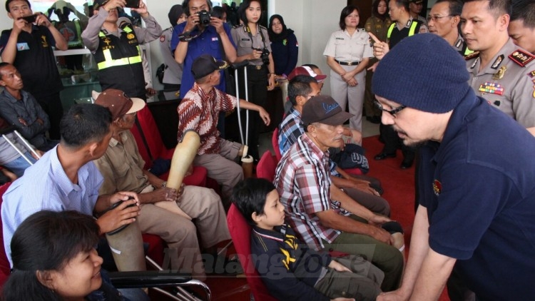 Andy F. Noya saat bercengkrama dengan penerima bantuan kaki palsu, di Balai Kota Among Tani, Selasa (8/8). (Aziz Ramadani)