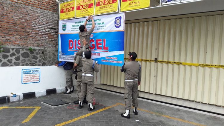 Petugas Satpol PP Kota Batu menyegel minimarket tak berizin di Desa Punten, Kecamatan Bumiaji, Jumat (27/10). (istimewa)