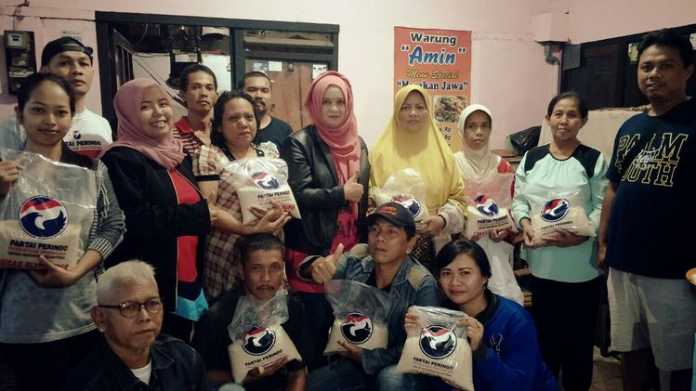 Ketua DPD Partai Perindo Kota Malang, Laily Fitriyah Liza Min Nelly bersama warga usai menyalurkan beras. (istimewa)