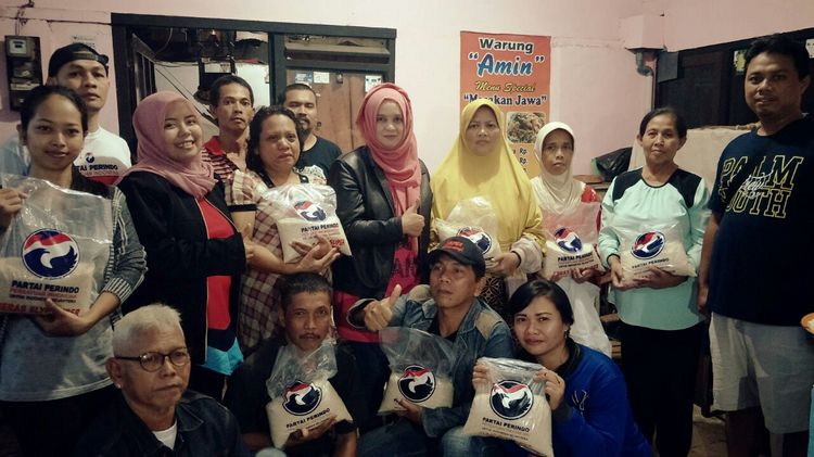 Ketua DPD Partai Perindo Kota Malang, Laily Fitriyah Liza Min Nelly bersama warga usai menyalurkan beras. (istimewa)