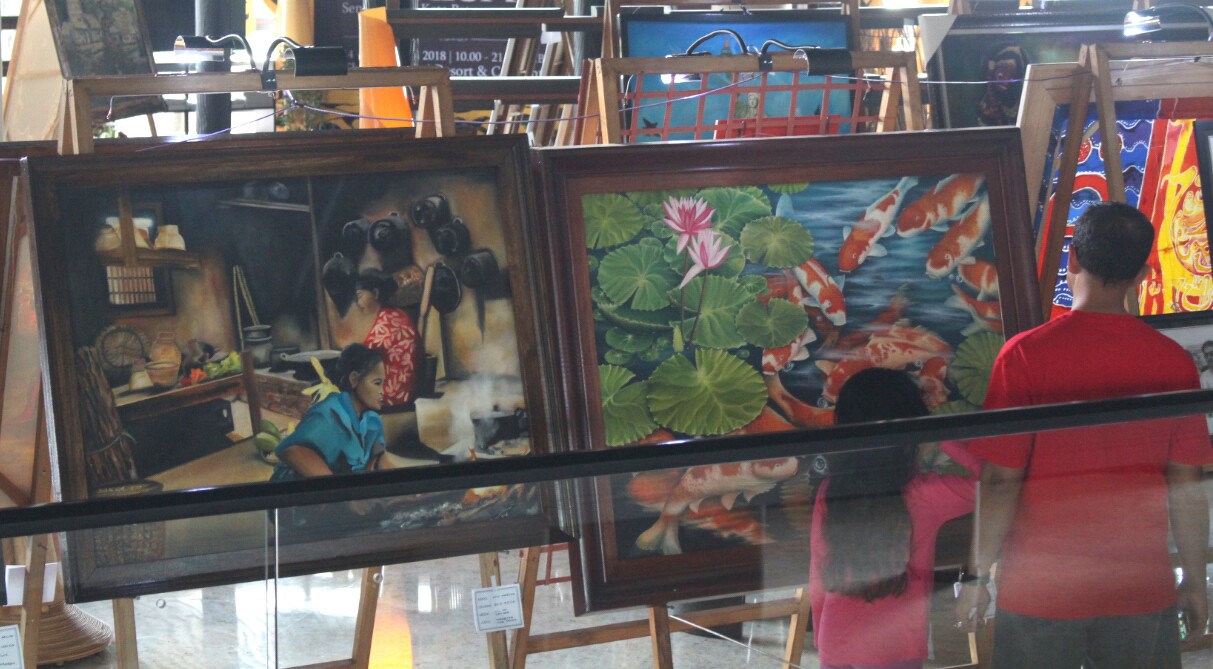 Pengunjung The Singhasari Resort menikmati pameran lukisan dari komunitas Akarasa KWB, Sabtu (17/2). (Aziz / MVoice)