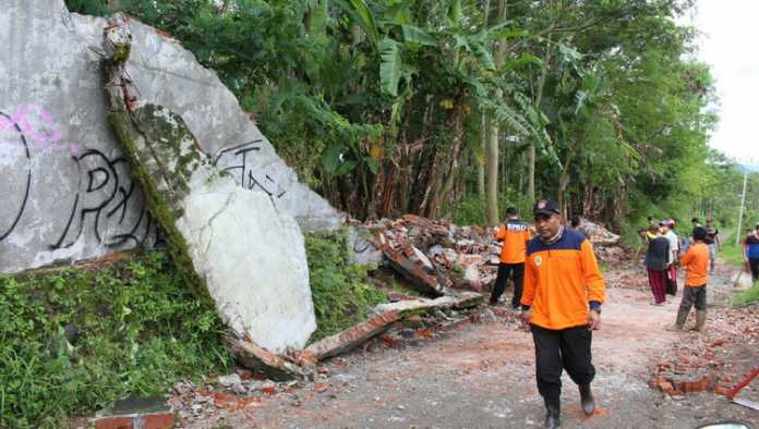 Tembok di Jalan Trunojoyo Tlekung Junrejo ambrol dibersihkan BPBD Kota Batu bersama relawan dan warga, Minggu (25/2). (Aziz / MVoice)