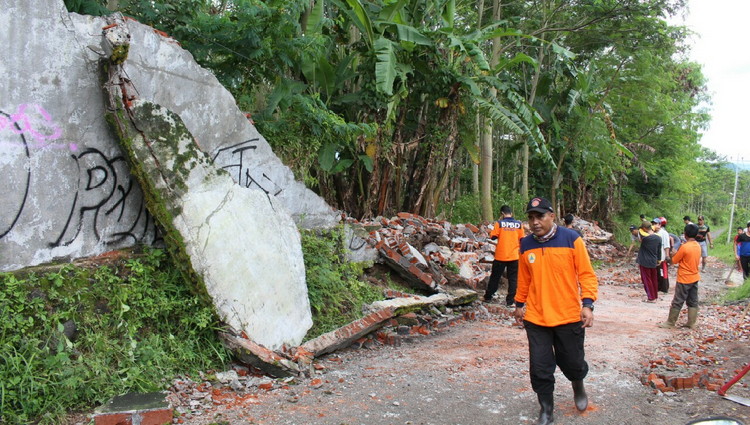 Tembok di Jalan Trunojoyo Tlekung Junrejo ambrol dibersihkan BPBD Kota Batu bersama relawan dan warga, Minggu (25/2). (Aziz / MVoice)