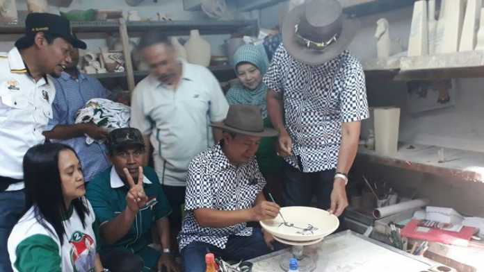 Anton-Syamsul saat mencoba membuat keramik di Kampung Keramik Dinoyo. (Lisdya Shelly)