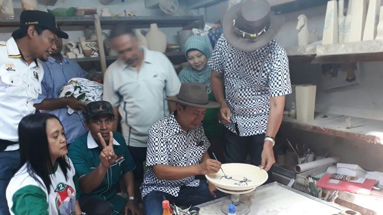 Anton-Syamsul saat mencoba membuat keramik di Kampung Keramik Dinoyo. (Lisdya Shelly)