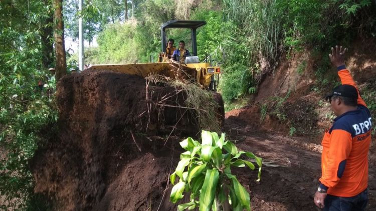 Petugas BPBD Kota Batu dibantu TNI, Polri, DPK Kota Batu, relawan dan warga membersihkan material longsor di Tulungrejo Bumiaji, Selasa (6/3). (BPBD Kota Batu)