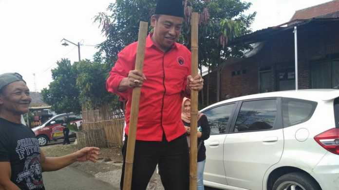 Calon Wakil Wali Kota Malang, Ahmad Wanedi, menjajal permainan tradisional egrang. (Muhammad Choirul)