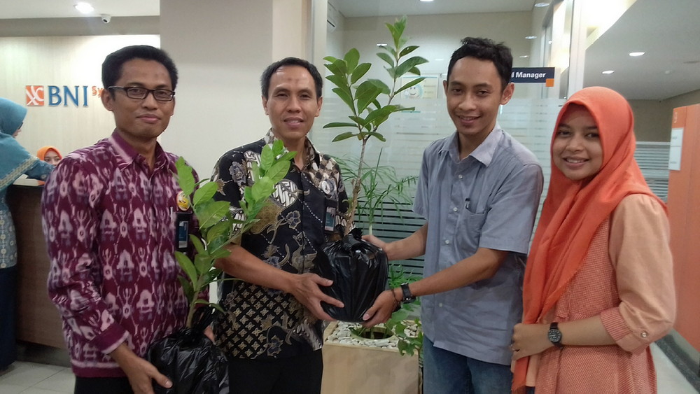 Branch Manager BNI Syariah cabang JA Suprapto, Bahaudin, saat memberikan bibit tanaman kepada nasabah baru. (Lisdya Shelly)