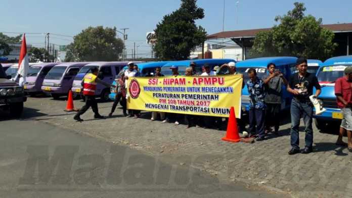 Ratusan sopir angkutan umum konvesional saat menggelar aksi unjuk rasa di halaman parkir Kantor UPT Dishub LLAJ Malang, di Jalan Raya Karanglo, Kecamatan Singosasi. (Toski D)