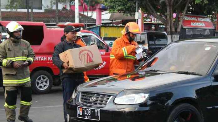 Anggota DPK Kota Batu berseragam lengkap bagikan takjil di Jalan Gajah Mada Kota Batu, Sabtu (26/5). (Aziz Ramadani / MVoice)