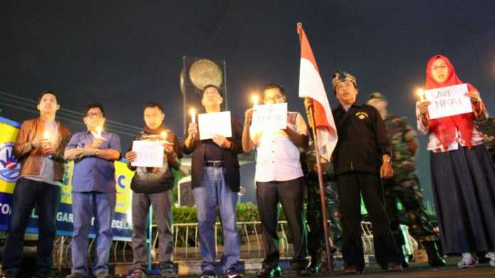 GusDurian dan masyarakat Kota Batu menyalakan lilin tanda berkabung peristiwa bom di Surabaya, Minggu malam (13/5). (Aziz Ramadani/ MVoice)