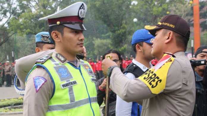 Kapolres Malang Kota AKBP Asfuri memasangkan pita kepada anggota. (Istimewa)