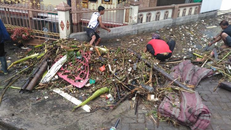 Warga dan petugas BPBD Kota Batu membersihkan sampah yang menyumbat sungai irigasi Desa Torongrejo, Rabu (20/6). (Pusdalops BPBD Kota Batu)
