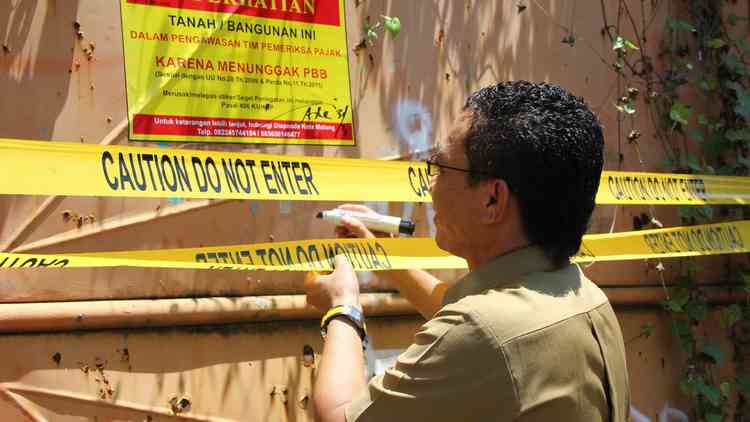 Kepala BP2D Kota Malang, Ir H Ade Herawanto MT memimpin langsung upaya tegas memasang stiker segel demi mengurai tunggakan pajak daerah. (istimewa)